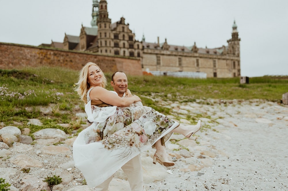 A couple in the front of Danish castle of Hamlet - See the Small Wedding Abroad Ideas from Nordic Adventure Weddings
