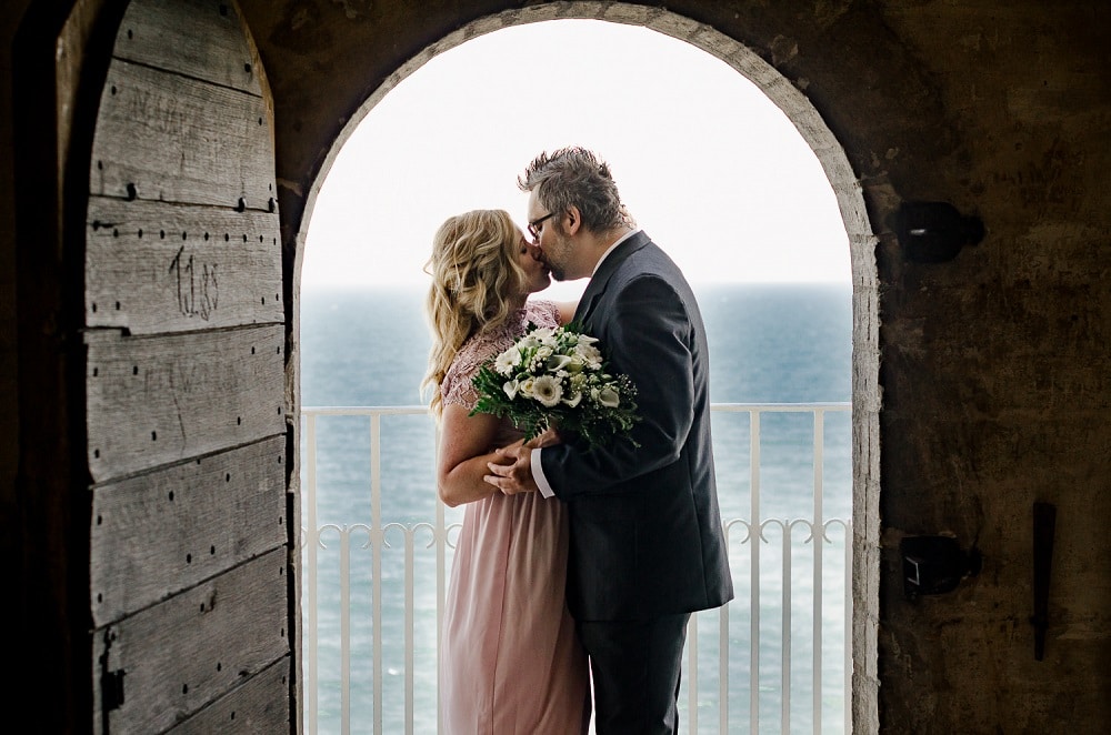 International couple get married in Denmark and say yes on the balcony of the ancient Church - See the Small Wedding Abroad Ideas from Nordic Adventure Weddings